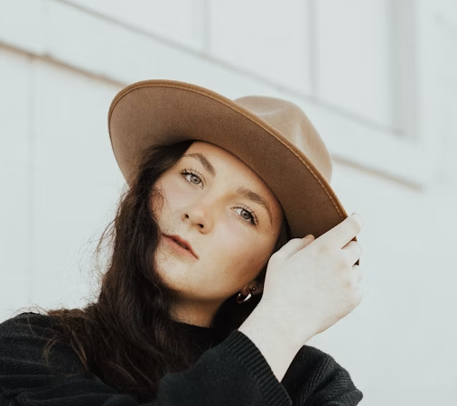 woman with dark hair in a brown hat